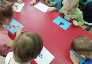 Dzieci rozdmuchują kroplę farby.