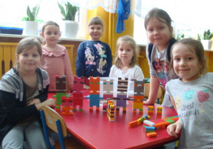 Dziewczynki układają ciekawe budowle z kolcków.