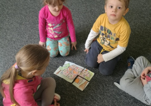 Kinga, Natalka, Jaś i Mateusz układają puzzle - odgadują z jakiej bajki to chatka.