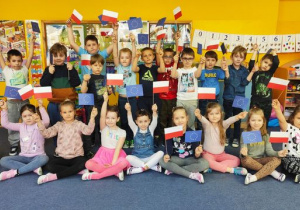 Skrzaty prezentują wykonane flagi Polski i Unii Europejskiej.