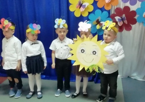 Przedszkolaki trzymają emblemat słoneczka.