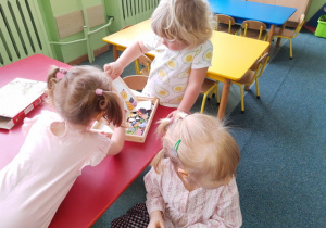 Dziewczynki układają obrazek na tablicy magnetycznej.