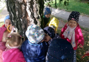 Dzieci obejmują drzewo.