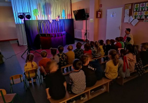 Dzieci oglądają przedstawienie w wykonaniu teatru lalek.
