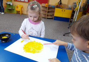 Ania i Marcelek malują słoneczko.