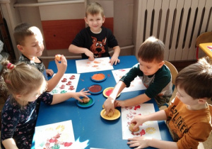 Dzieci tworzą obrazy z ziemniaków maczanych w farbie.