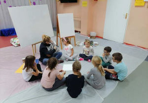 "Co namalujemy?" - dzieci i malarka zastanawiają się nad tematem prac.