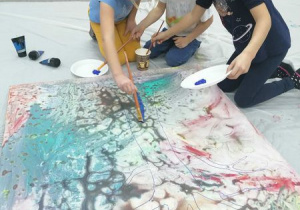 Dzieci malują tło obrazu.