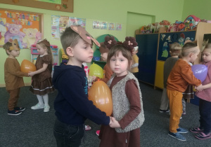 Zuzia i Grześ tańczą z balonem.