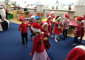 Dzieci tańczą do piosenki pt. "Kochany Panie Mikołaju".