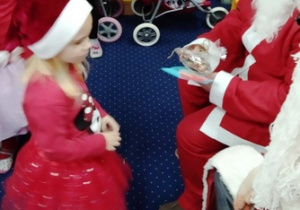 Sonia wręcza Mikołajowi pierniczki świąteczne.