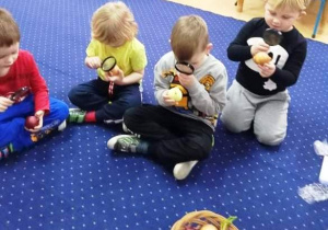 Dzieci oglądają cebulki pod lupą.