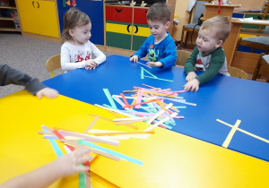 Dzieci wybierają kolorowe paski na swój łańcuch.