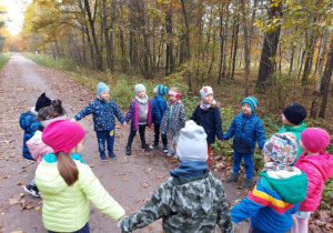 Dzieci wsłuchują się w odgłosy lasu.