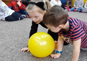 Ania i Krzyś próbują przesunąć balonik.