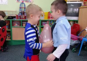Paweł i Miłosz tańczą z balonem.