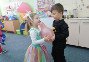 Laura i Mateusz tańczą z balonem.