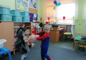 Gabryś i Oliwier tańczą z balonem.