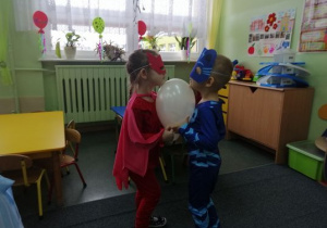 Laura i Piotruś tańczą z balonem.