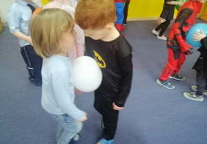 Mateusz i Kacper tańczą z balonem.