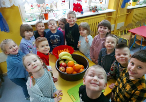 Dzieci prezentują zdrowe owoce i warzywa.