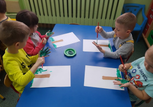 Biedronki malują swoją rączkę farbą.