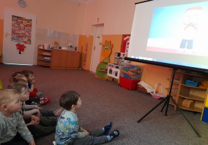 Dzieci oglądają film edukacyjny o symbolach narodowych.