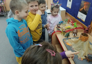 Dzieci oglądają świat dinozaurów.