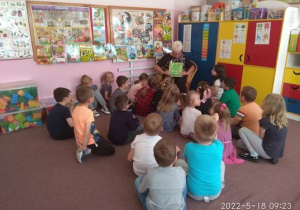 Dzieci ogladają ilustracje do przeczytanej bajki.