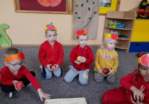 Dzieci słuchają opowiadania o jabłku.