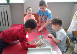 Wiojtek, Oskar, Sebastian i Marcel układają puzzle.