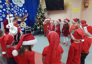 Dzieci śpiewają piosenkę Mikołajowi.