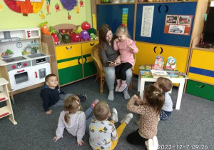 Dzieci słuchają uważnie czytanej bajki.