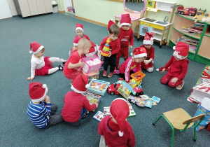 Dzieci rozpakowują prezenty od św. Mikołaja