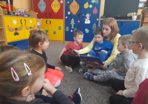 Dzieci słuchają czytanych bajek.