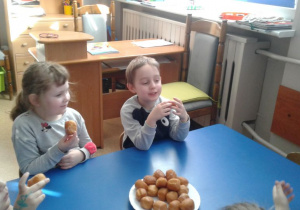Nikola i Olek jedzą pączki.