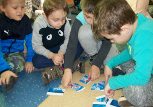 Chłopcy układają bajkowe puzzle.